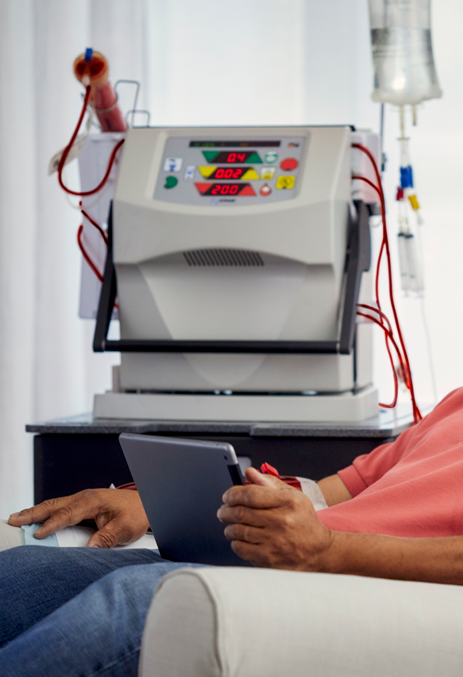 Man reading tablet while undergoing Dialysis