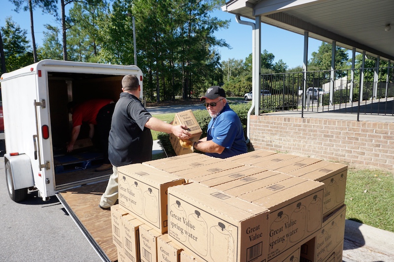 Community members unloading supplies from a trailer 