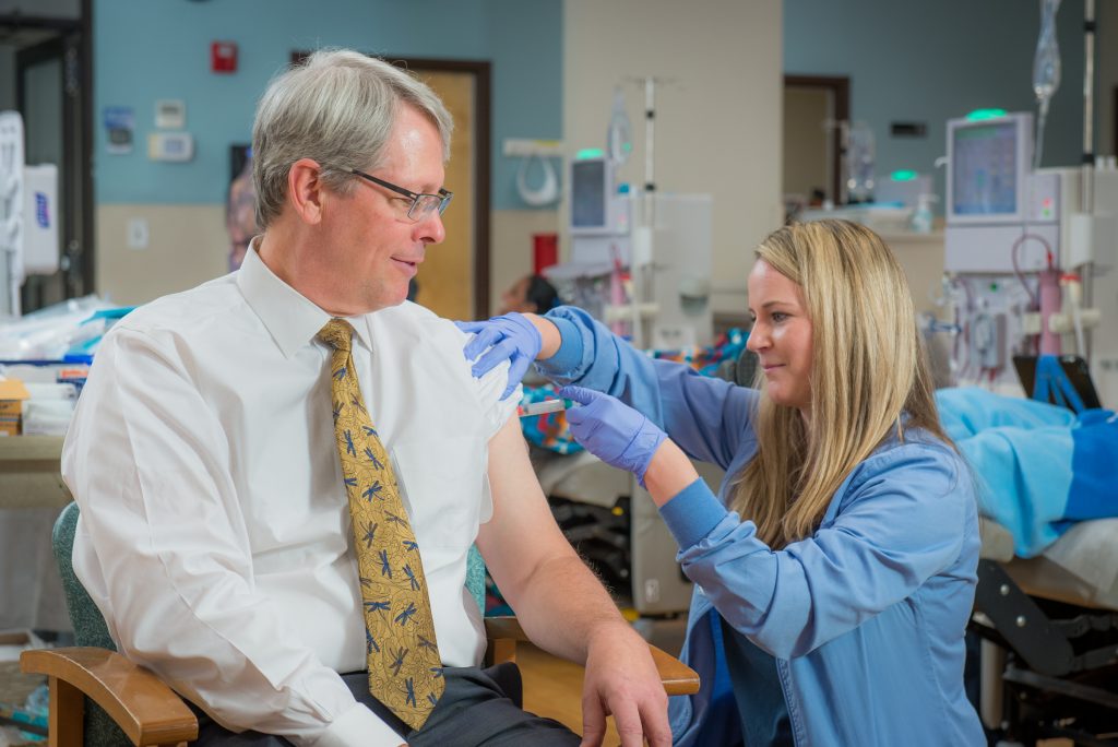 Dr. Frank Maddux, FMCNA Chief Medical Officer, receives his annual flu shot from Clinic Manager, Margot Nelson, RN